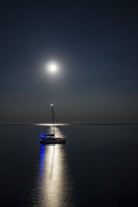barca a vela e riflesso della luna